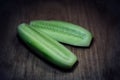 Two halves of sliced Ã¢â¬â¹Ã¢â¬â¹cucumber on a wooden board